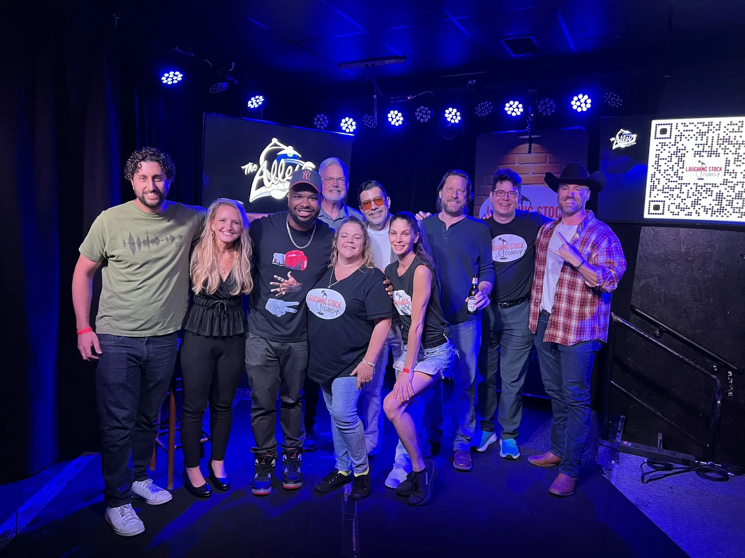 Laughing Stock Comedy comedians posing together on stage at The Alley