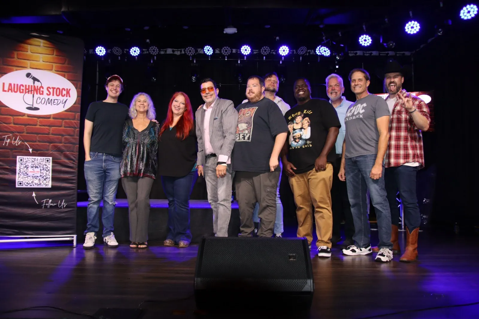 Laughing Stock Comedy comedians posing together on stage at Good Times Bar & Grill